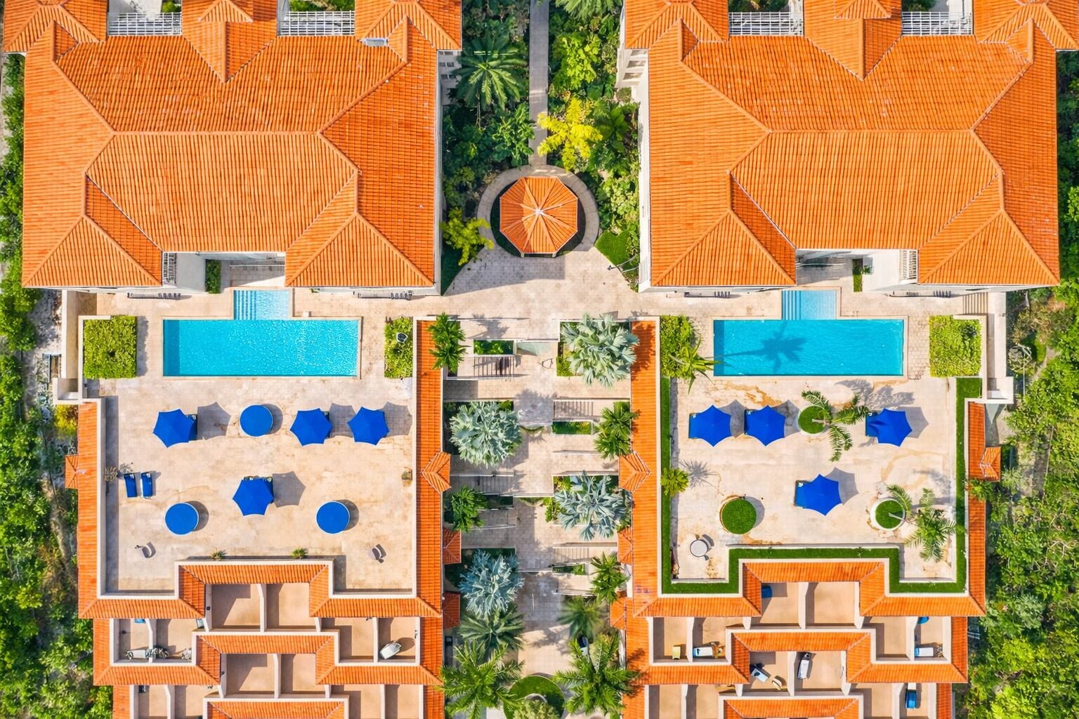 A resort with two swimming pools, lounge areas, and a central garden.