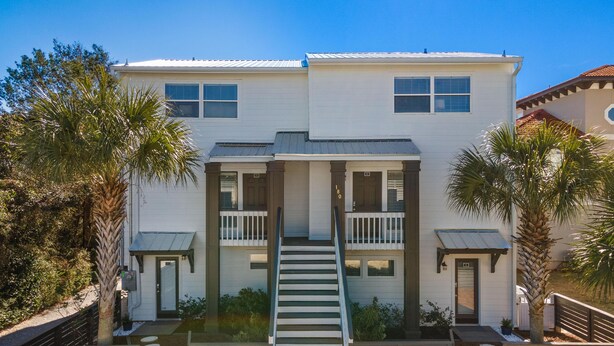 A two-story house with a central staircase, a balcony on the upper floor, and a gated entrance. - Coastal Classic Blue Mountain Beach Condo! (Santa Rosa Beach)