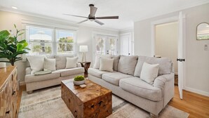 A modern living room with two grey sofas, a wooden coffee table, and a ceiling fan. - Coastal Classic Blue Mountain Beach Condo! (Santa Rosa Beach)