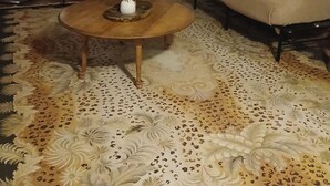 Een woonkamer met een bank, een fauteuil, een salontafel en een televisie.