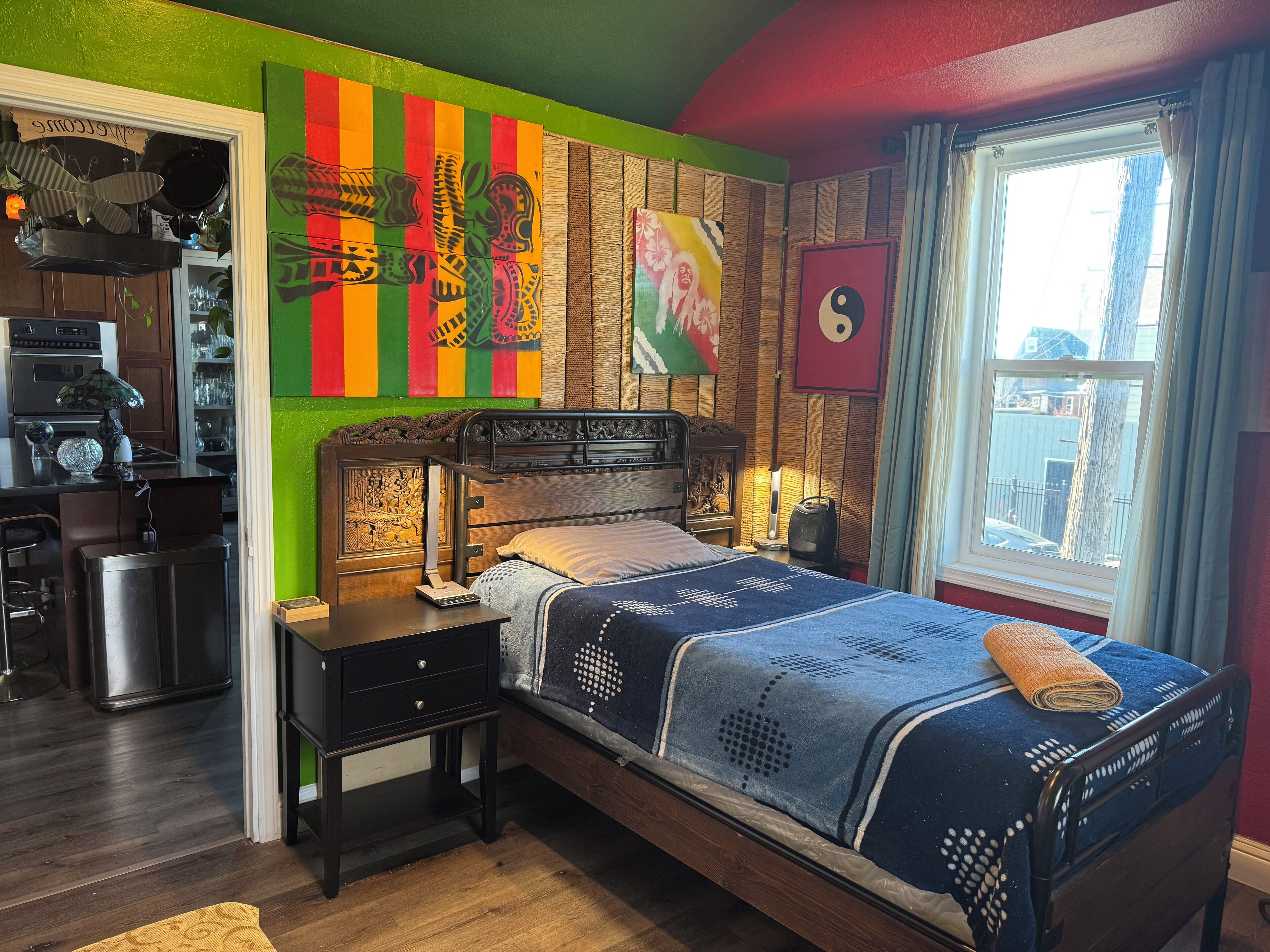 Une chambre à coucher avec un lit, une table de chevet et une fenêtre avec des rideaux.