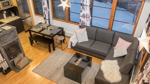 Una sala de estar moderna con chimenea, un sofá, una mesa de comedor y una zona de cocina.