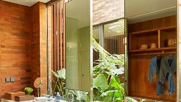 Une salle de bain moderne avec deux vasques, un grand miroir et un meuble-lavabo en bois agrémenté de serviettes.