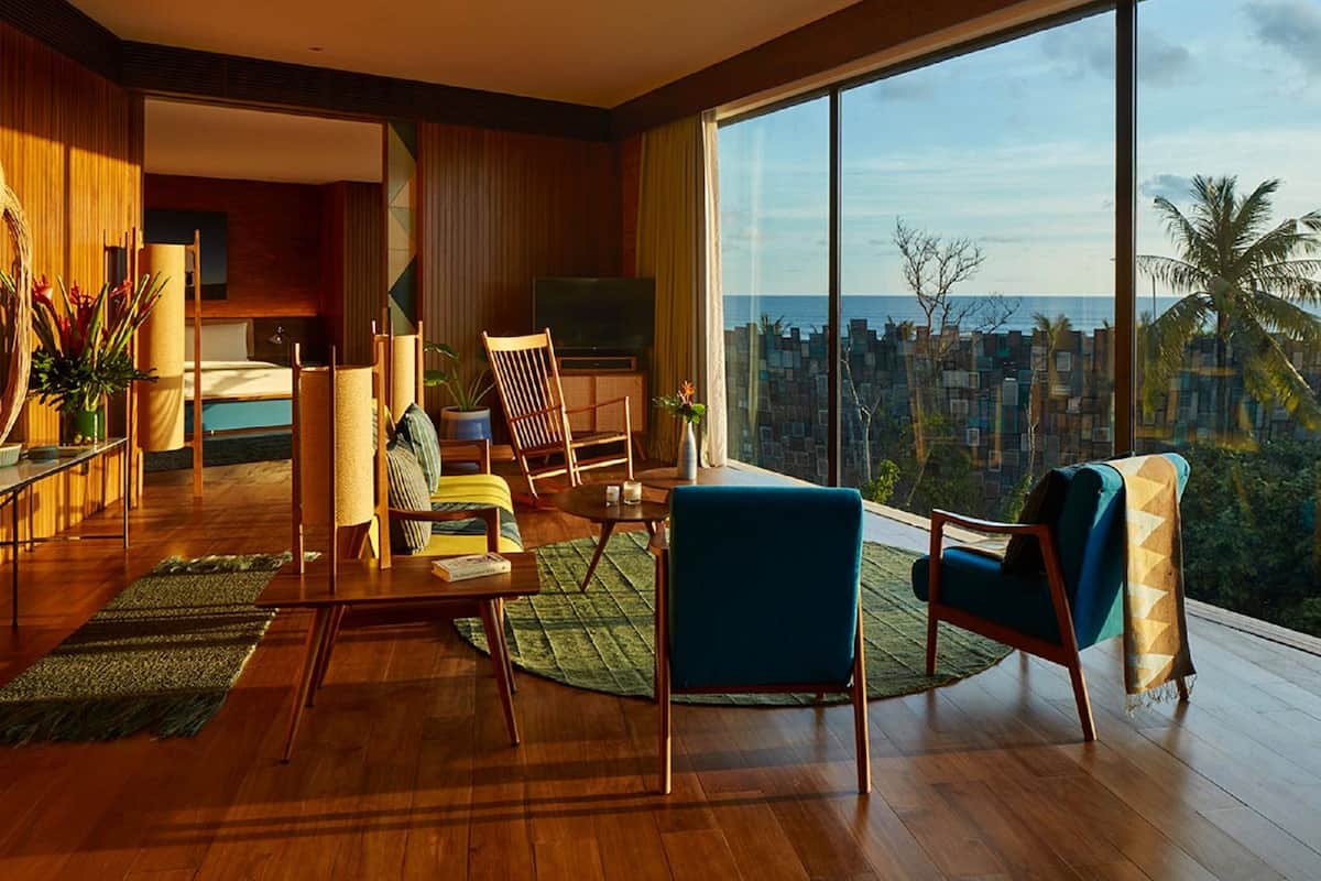 A modern living room with a large window, wooden flooring, and a view of the cityscape.