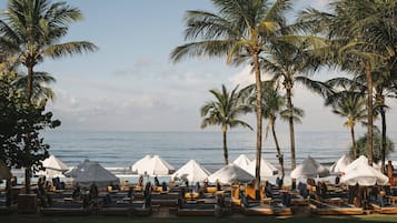 On the beach, white sand, beach cabanas, sun loungers