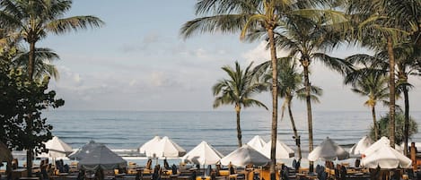 On the beach, white sand, beach cabanas, sun loungers