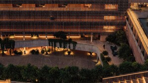 A modern building with a tiered seating area, possibly for events, surrounded by greenery and a pool. - Desa Potato Head Bali (Keroboken Kelod)
