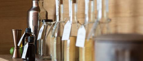 A variety of glass bottles and metal containers on a wooden shelf.