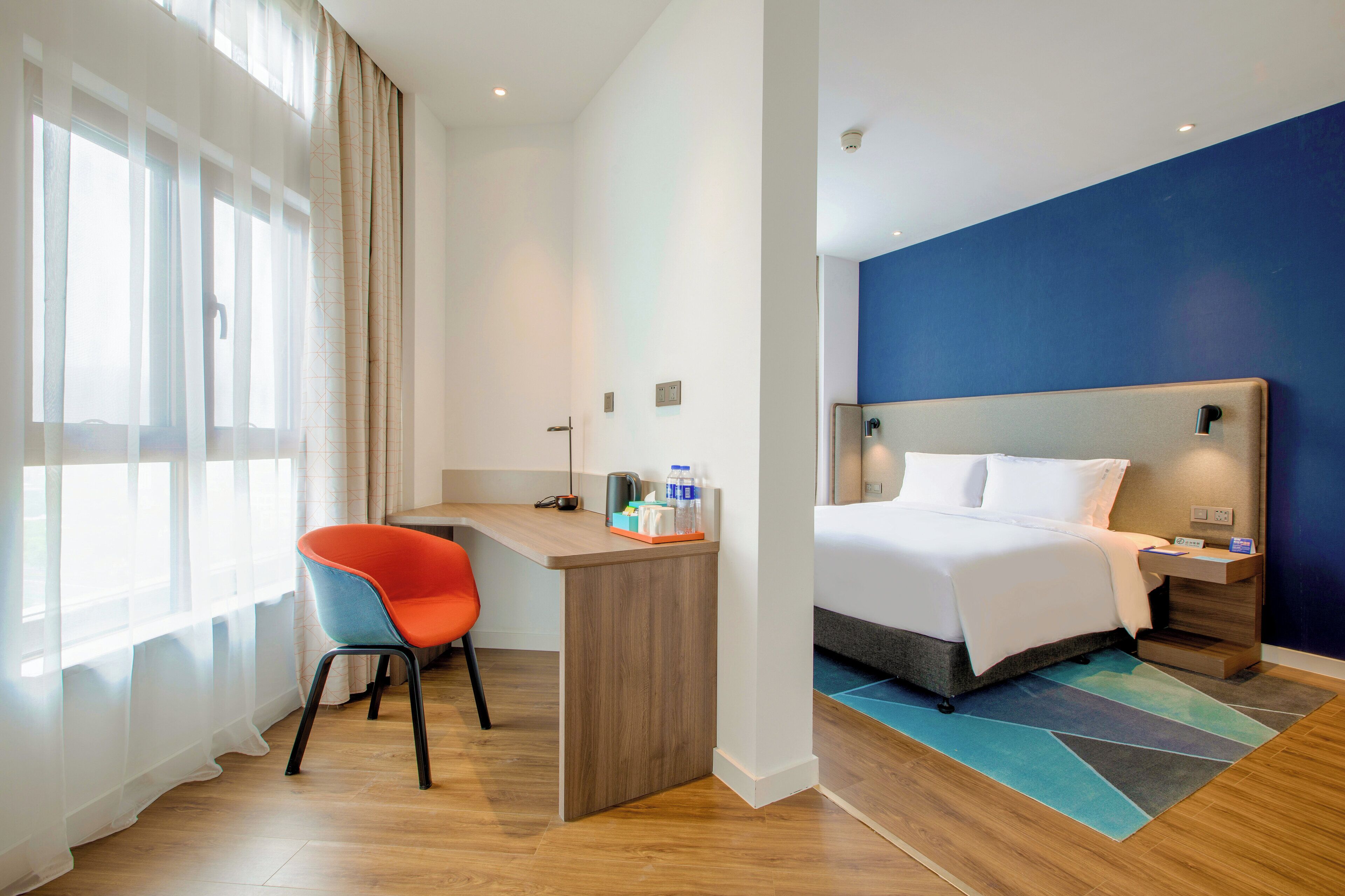 Een hotelkamer met een bed, een bureau en een stoel.