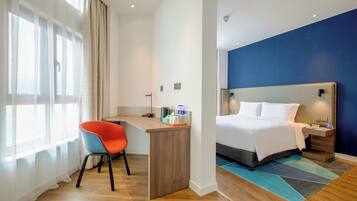 Een hotelkamer met een bed, een bureau en een stoel.