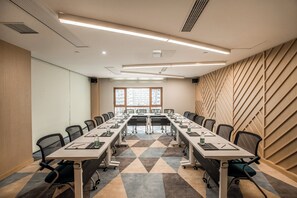 A conference room with a long table, chairs, and a view of buildings through large windows. - Holiday Inn Express Zhangjiagang Free Trade Zone by IHG (Suzhou)
