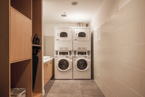A laundry room with two stacked front-loading washing machines and a dryer. - Holiday Inn Express Zhangjiagang Free Trade Zone by IHG (Suzhou)