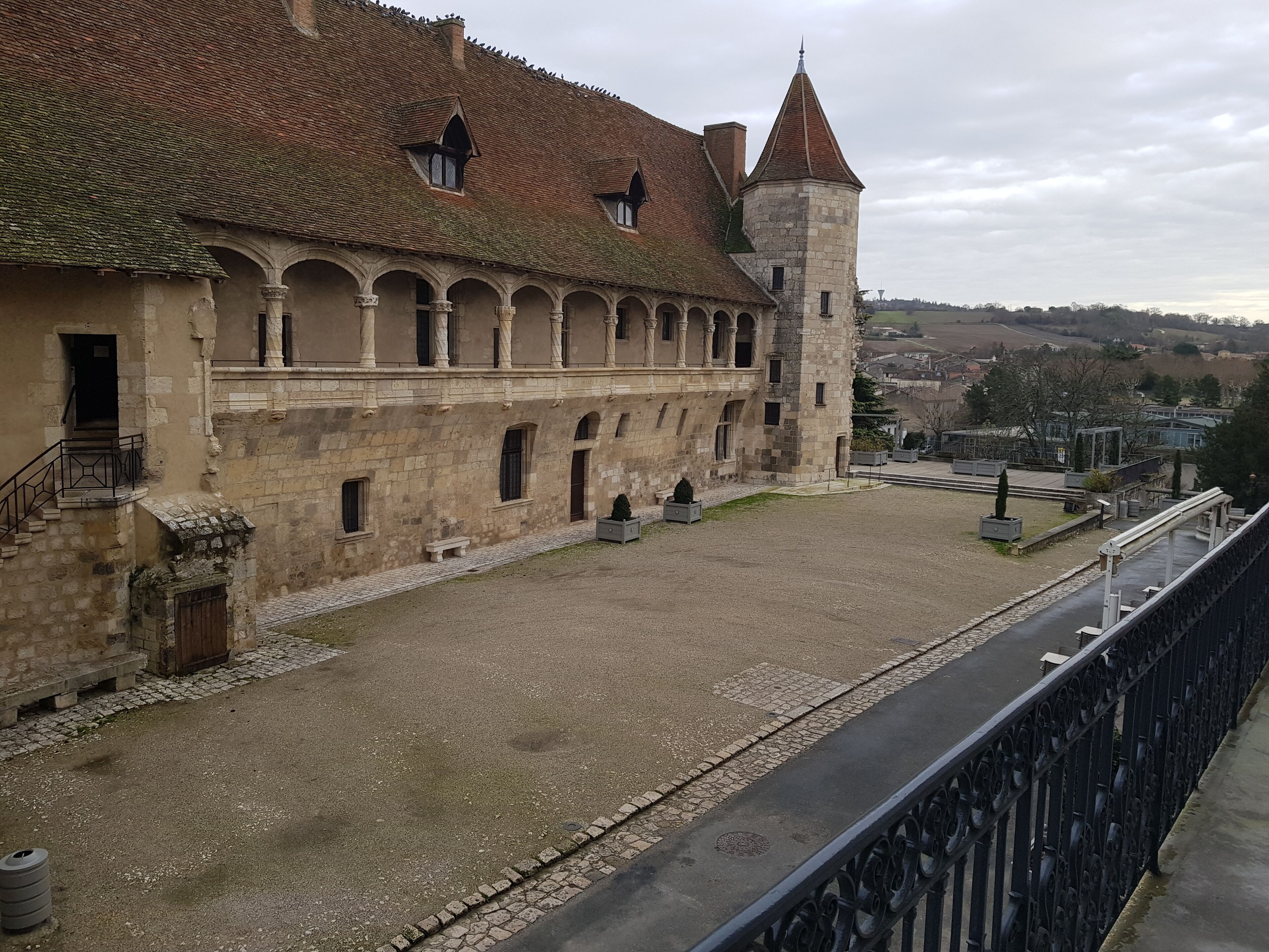 A historic building with a courtyard, stone walls, and a tower.