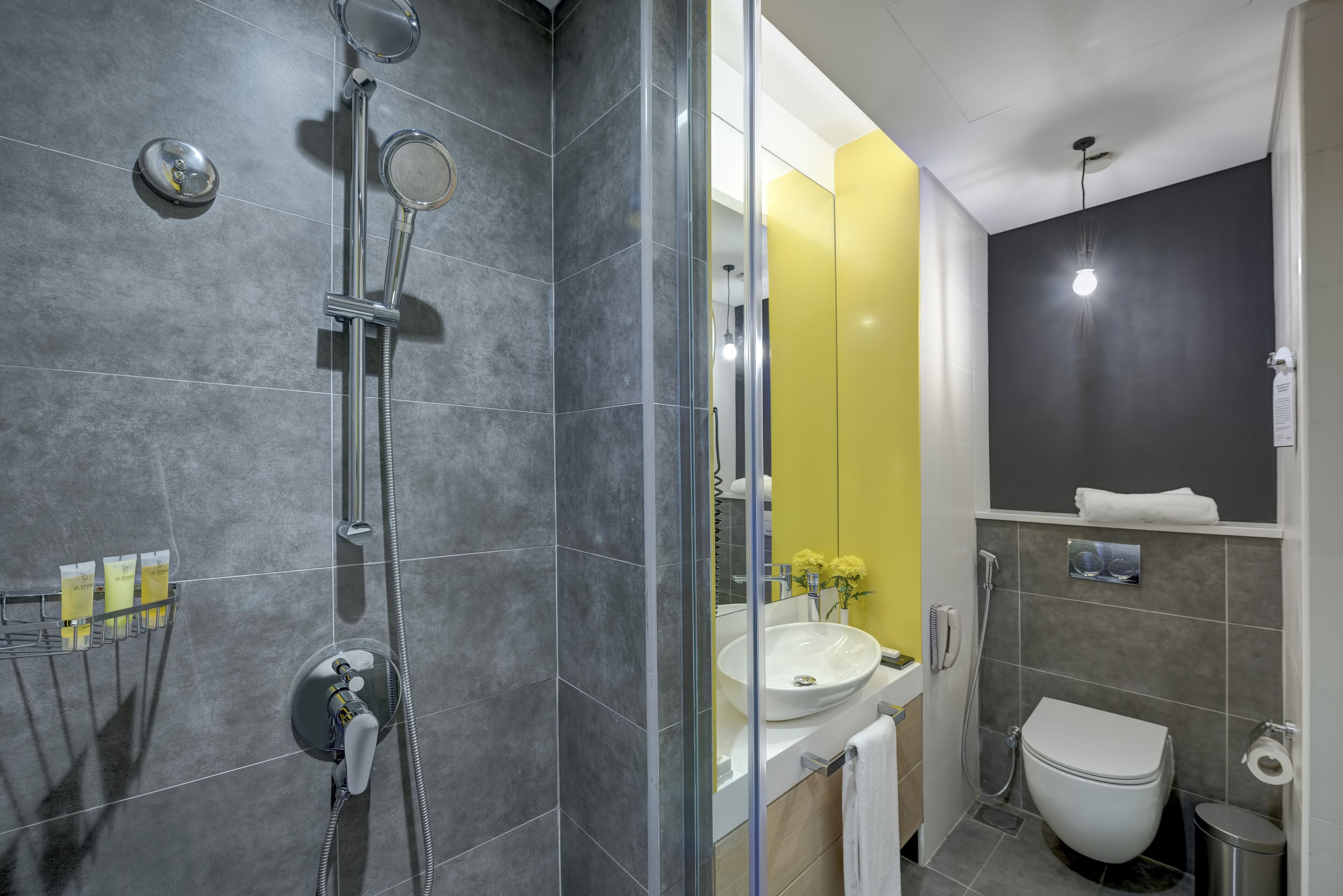 A modern bathroom with a glass-enclosed shower, a sink, and a toilet.