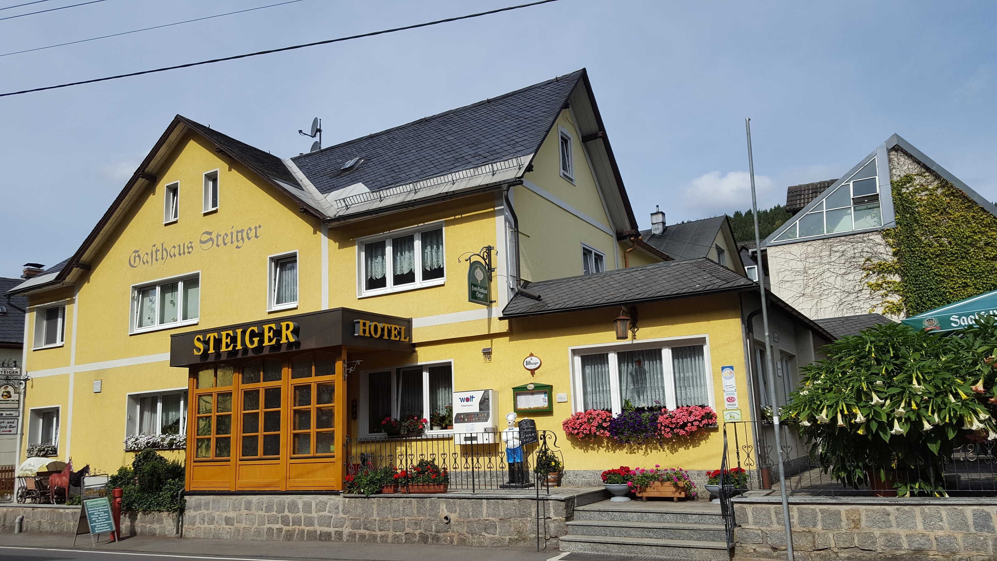 A two-story building with a sign reading 'Steiger Hotel' and a visible entrance with a wooden door.