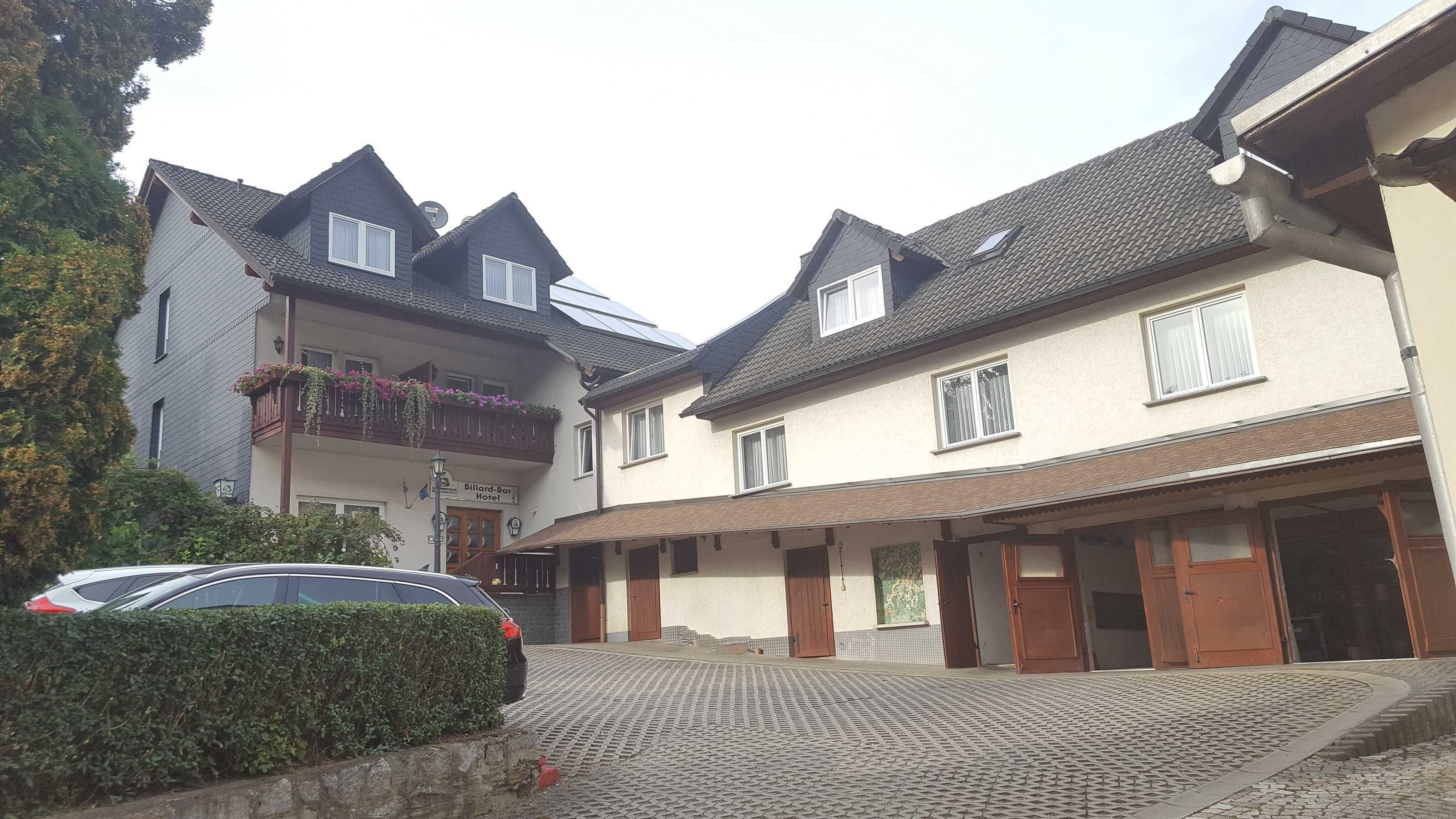 Ett hotell med en traditionell europeisk arkitektur, med en central innergård, många fönster och en skylt som visar att det är ett hotell.