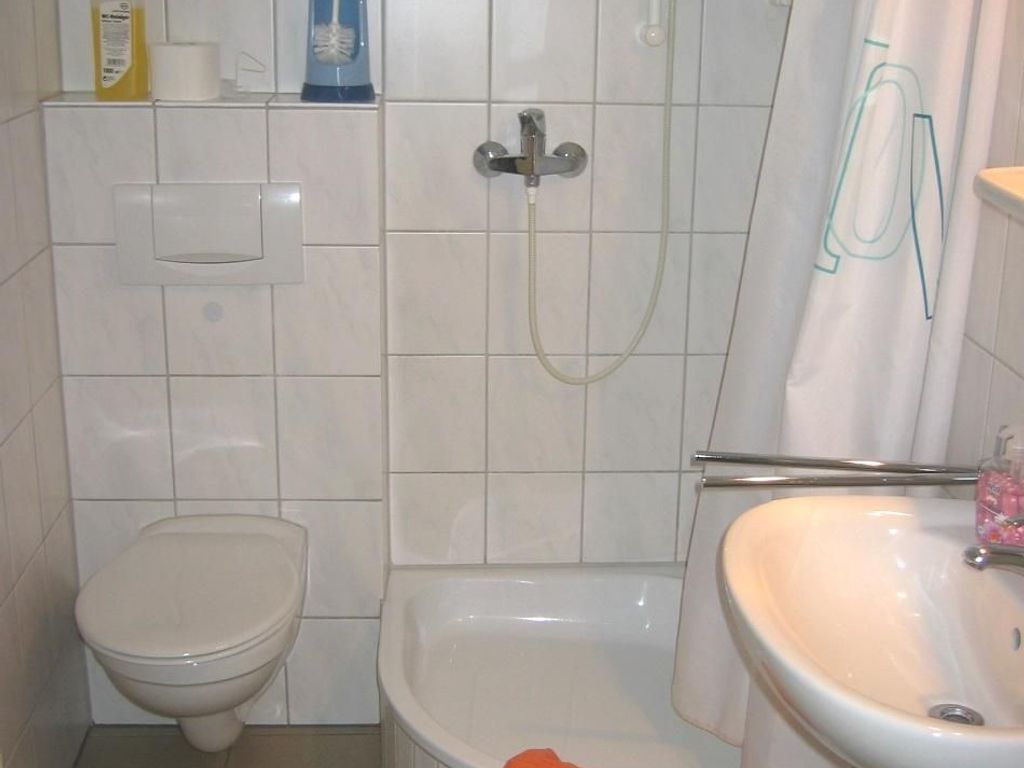 Een badkamer met een toilet, douche en wastafel.