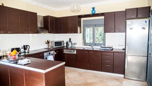 Una cocina moderna con armarios de madera oscura, electrodomésticos de acero inoxidable y una isla central.