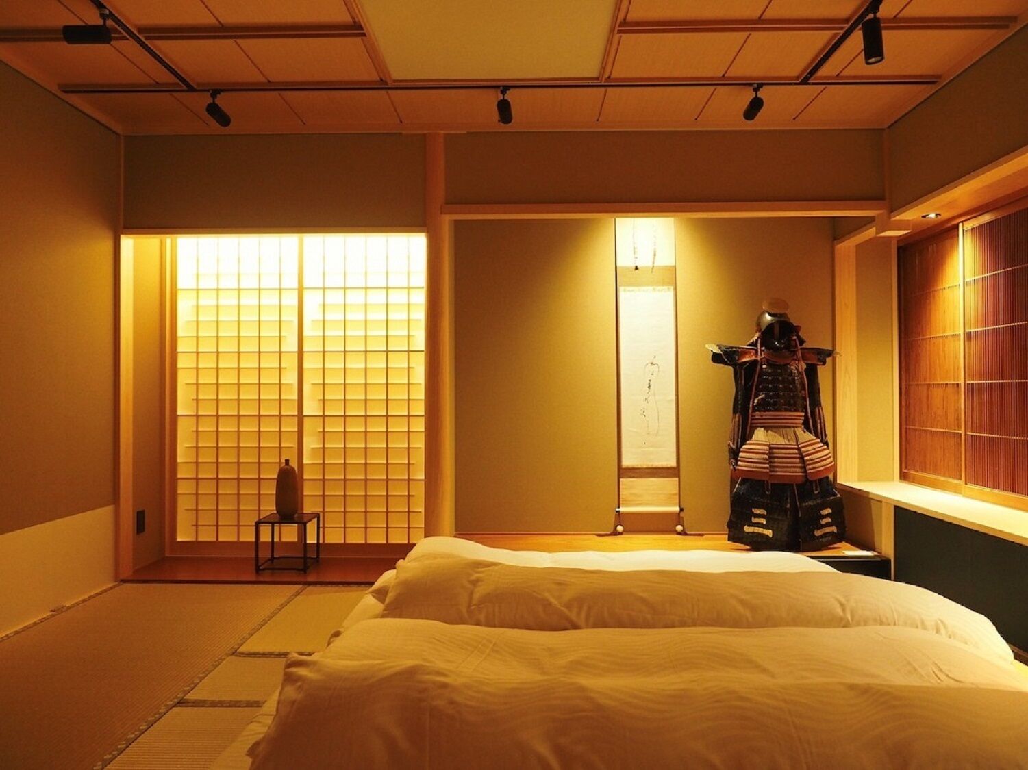 Een traditionele Japanse kamer met tatami vloerbedekking, een bed, een shoji schuifwand en een display met samurai harnassen.