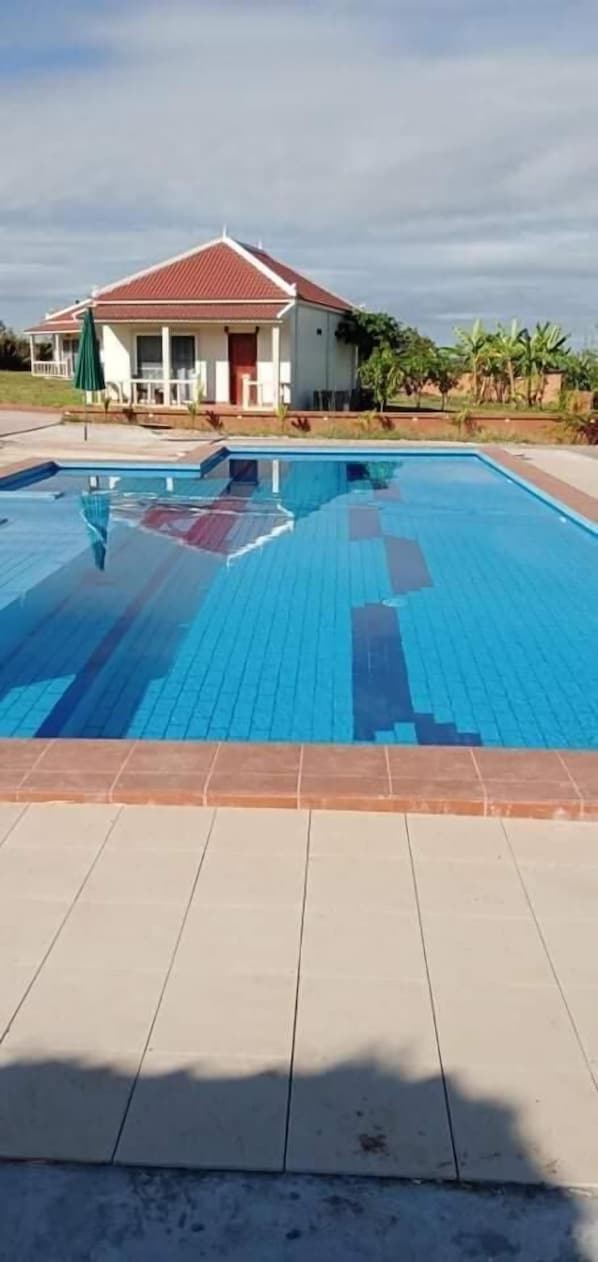 Piscina a l'aire lliure, para-sols i gandules