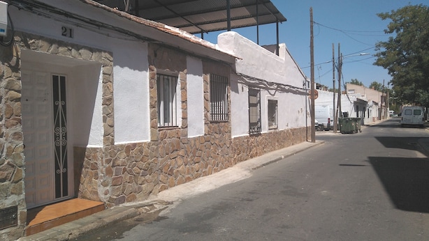 A street view of a building with a stone facade, numbered 21, and a white exterior. - Cozy and central bass (Ciudad Real)