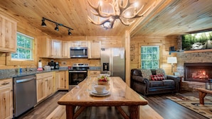 L’intérieur d’une cabane en bois comprend une cuisine, un coin repas et un salon.