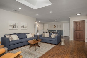 A modern living room with two sofas, a coffee table, and a rug.