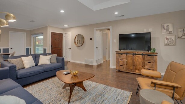 A modern living room with a sofa, coffee table, and TV stand.