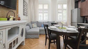 Un salon moderne comprenant un canapé, une table à manger et un coin cuisine.