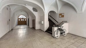Un hall d’entrée spacieux, doté d’un sol carrelé, de murs blancs et d’un escalier muni d’une rampe.