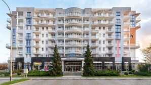 Ein mehrstöckiges Hotel mit Balkonen, einem zentralen Eingang und einem Schild mit der Aufschrift 'HOTEL DIVA SPA'.