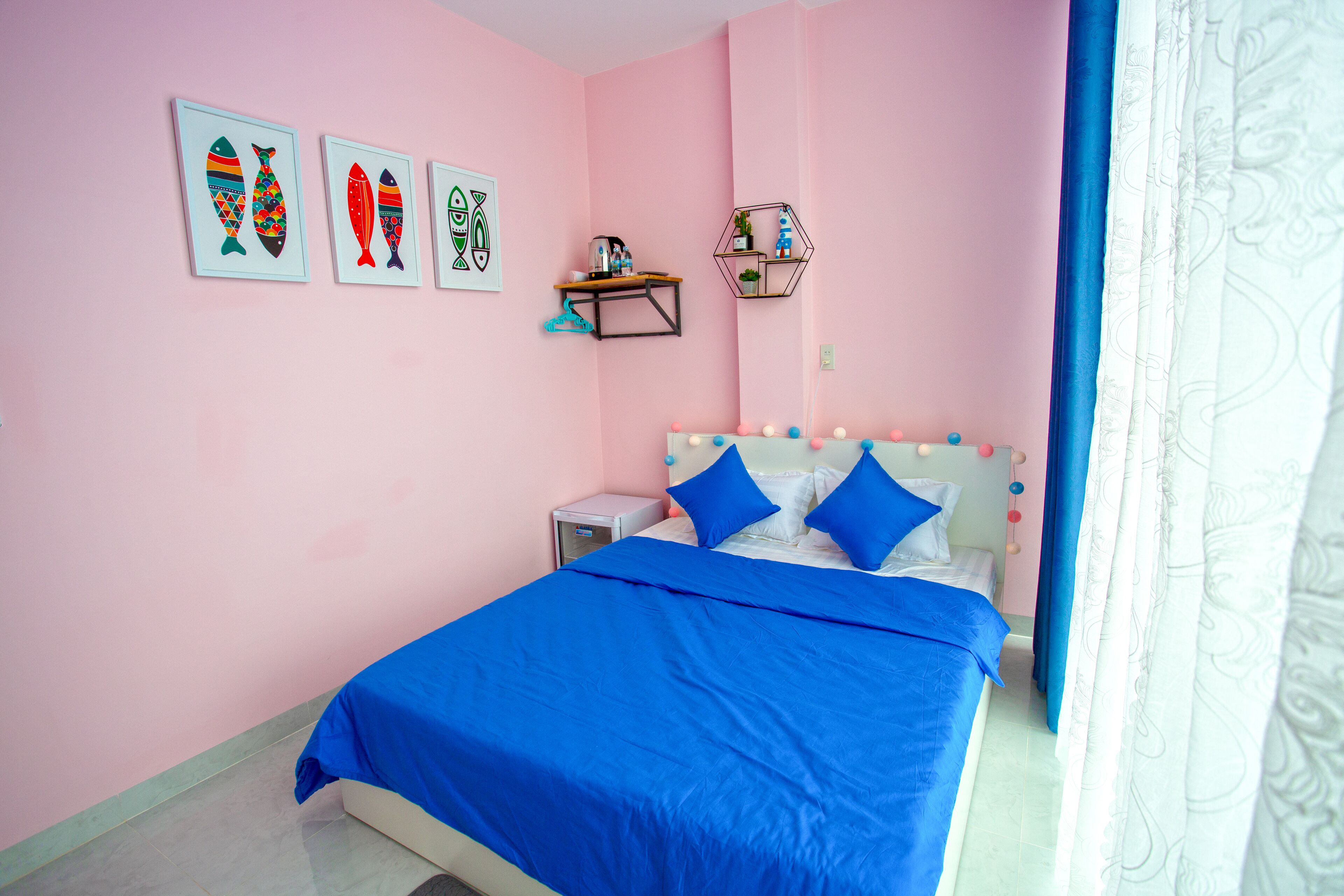 Een slaapkamer met een bed, een nachtkastje, een plank met decoratieve objecten en wanddecoratie.