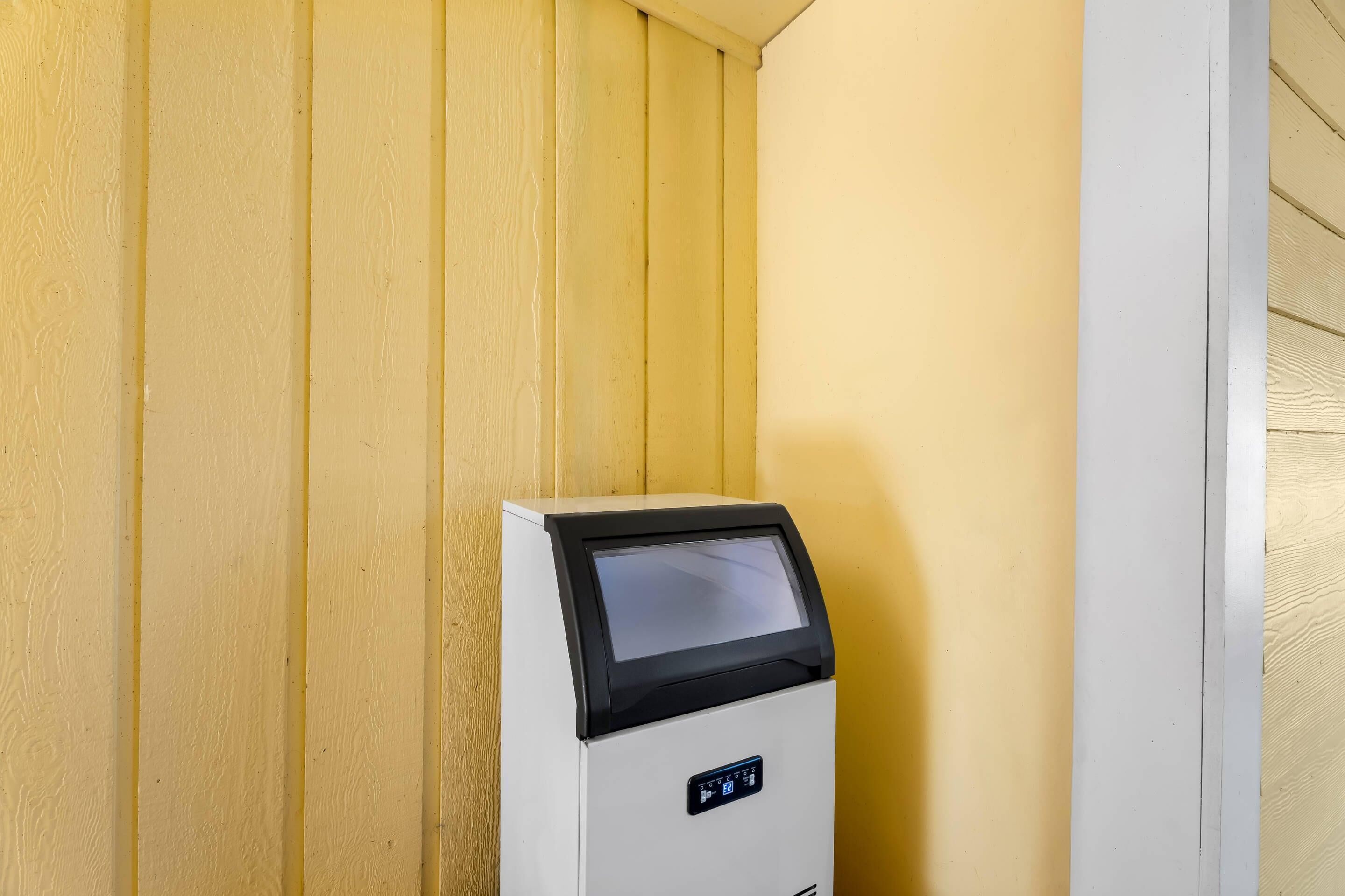 Un quiosco de autoservicio con pantalla digital, ubicado frente a una pared de madera.