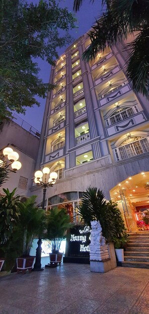 A multi-story hotel with balconies, a well-lit entrance, and a sign reading "Hotel". - Hoang Quan Hotel (Ho Chi Minh City)