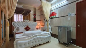 Une chambre d’hôtel spacieuse, dotée d’un grand lit, d ’une table de chevet, d’une commode et d’une armoire.