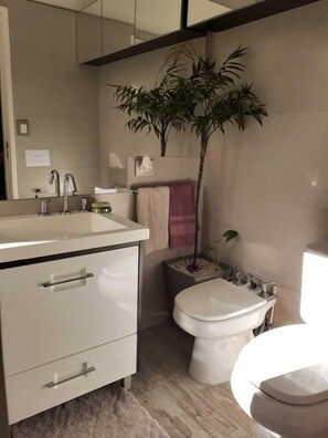 Een douche, een bidet, handdoeken, toiletpapier