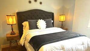 Una camera da letto con un letto grande, due lampade da comodino e un elemento decorativo a parete.