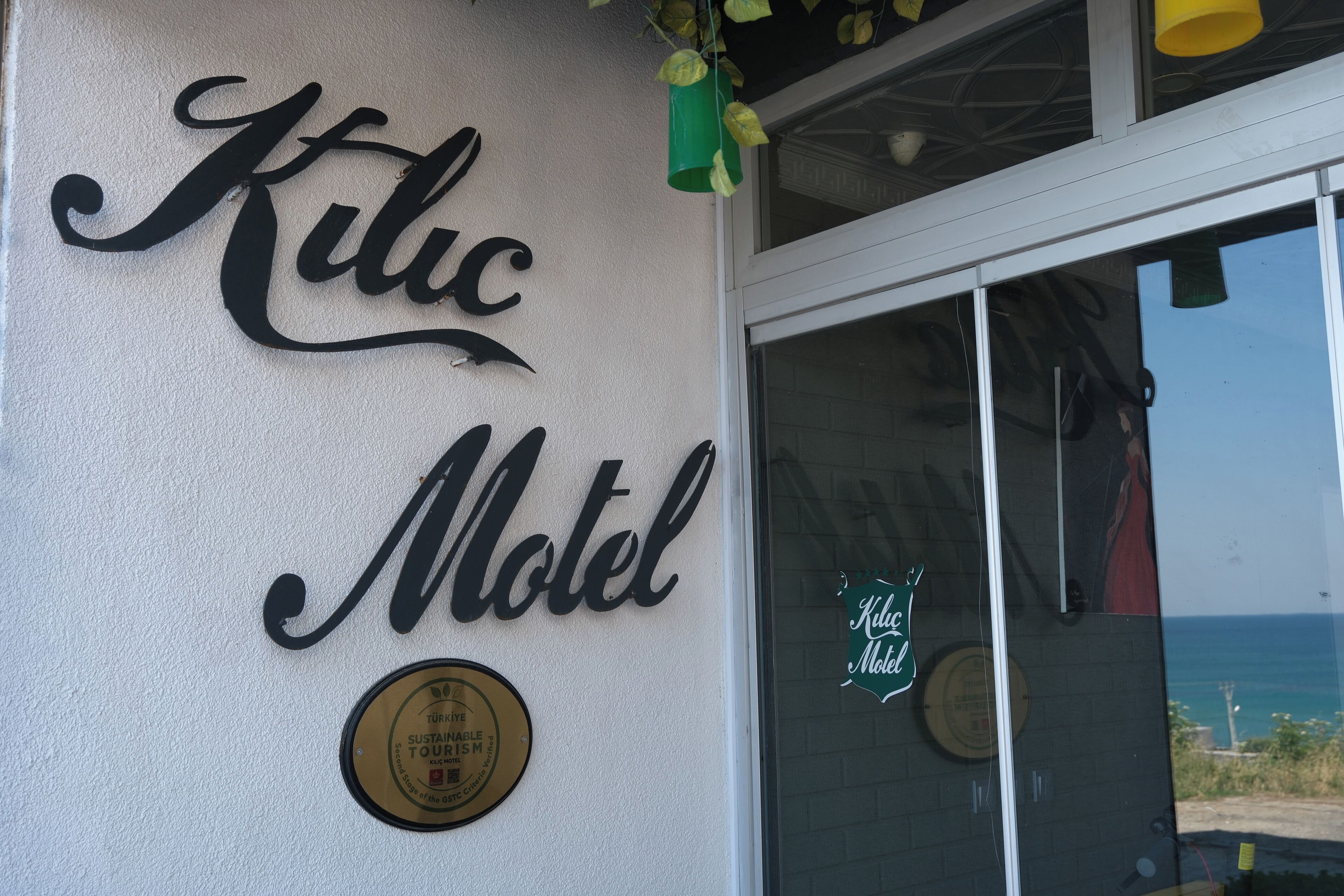 Une enseigne indiquant « Kilic Motel », agrémentée d’un logo attestant de sa certification en matière de développement durable.