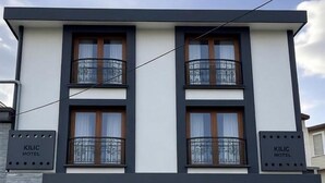 A modern two-story building with a sign reading "KILIC MOTEL" on the facade. - Kilic Motel (Arnavutköy)