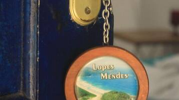 Une serrure de porte et un porte-clés avec une image représentant un paysage et l’inscription « Lopes Mendes ».