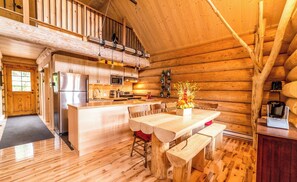 Cozy cabin with a central island, dining table, and bench, perfect for a relaxing stay.