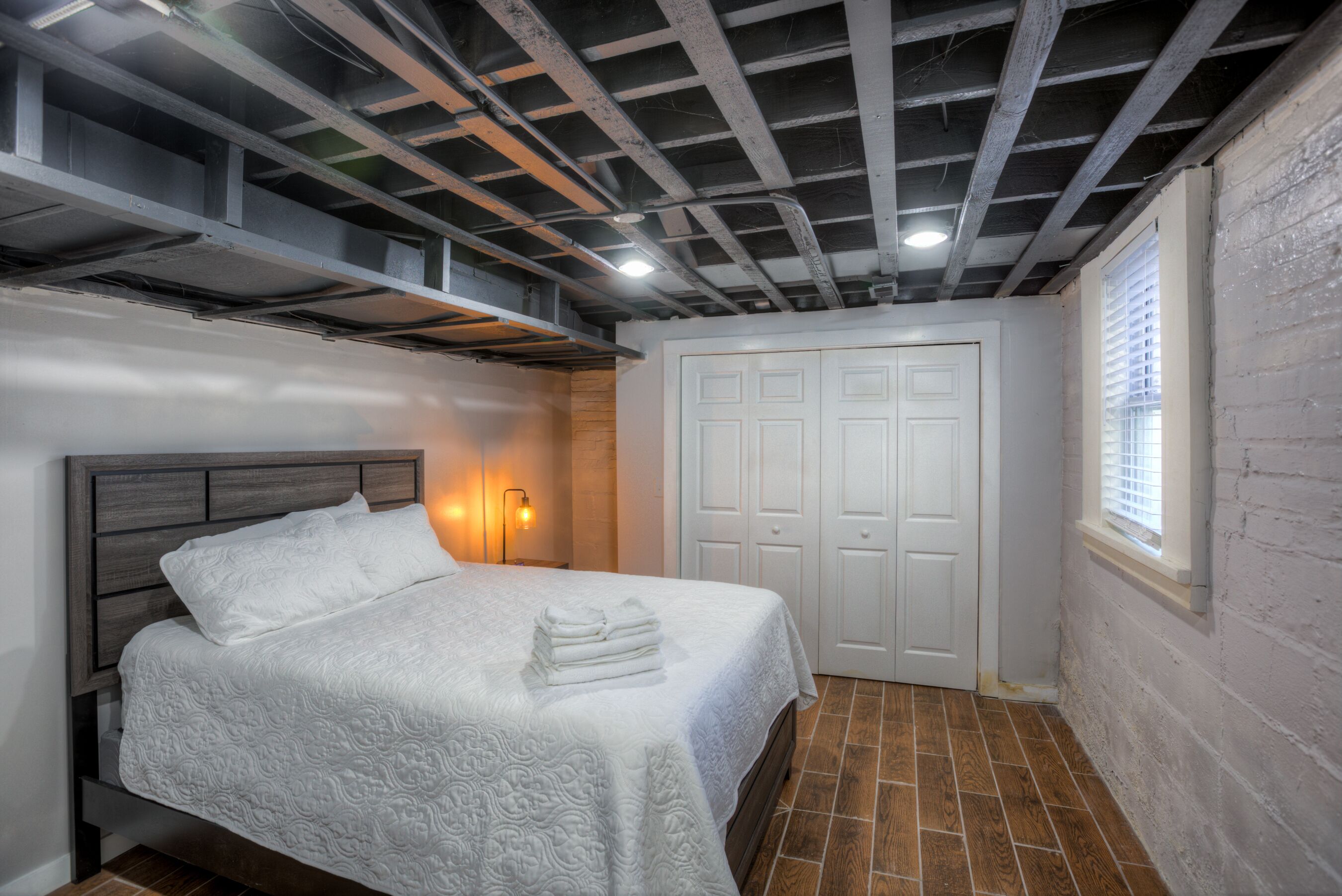 Ein Schlafzimmer mit einem Bett, einem Kleiderschrank und einem Fenster mit Jalousien.