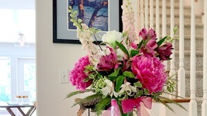 A wooden table with a vase of flowers and a sign reading "Otter's Pond."