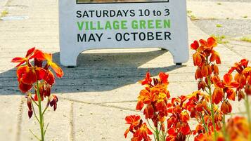 A sign for the Village Green Farmers Market, open Saturdays 10 to 3, May to October.