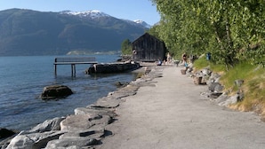 Un sentier de pierres bordant un lac, avec une structure en bois et un banc.