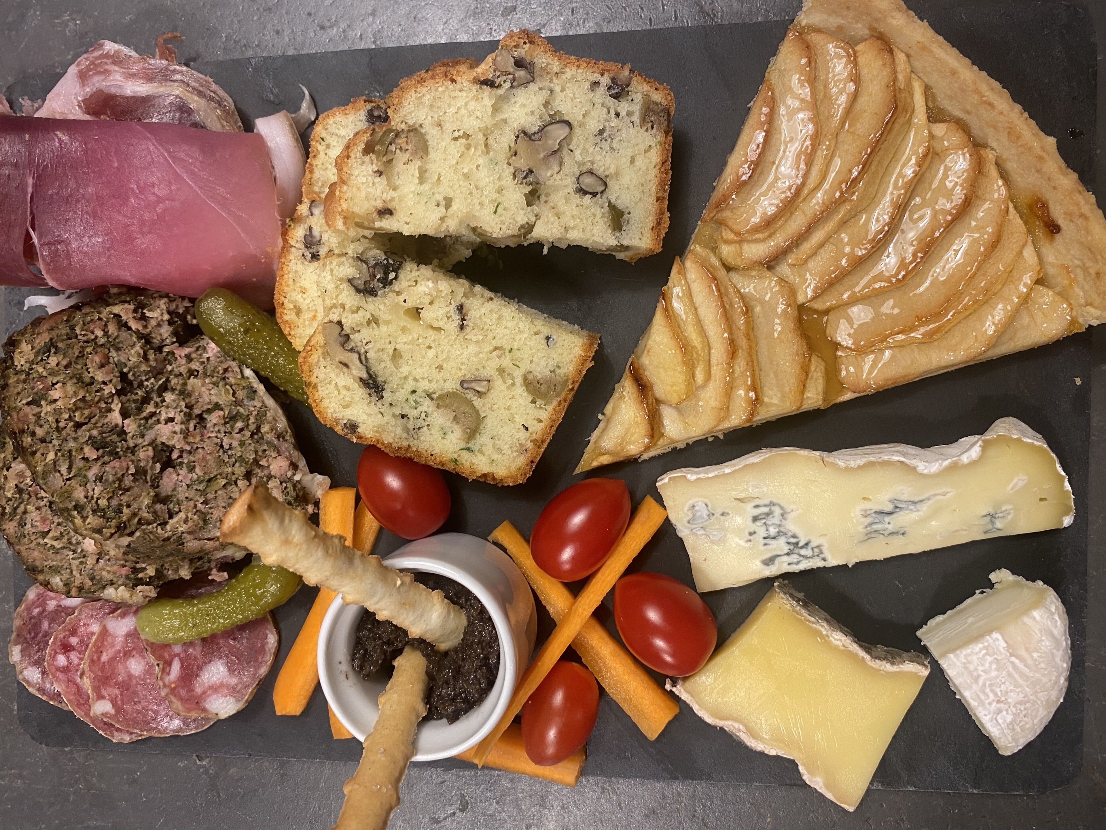 Eine Platte mit verschiedenen Wurstwaren, Käsesorten und Früchten.