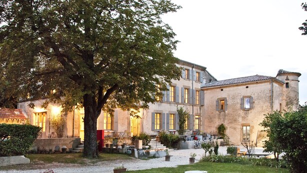 A historic building with a courtyard, stone steps, and a large tree. - La Grande Maison (Montmeyran)