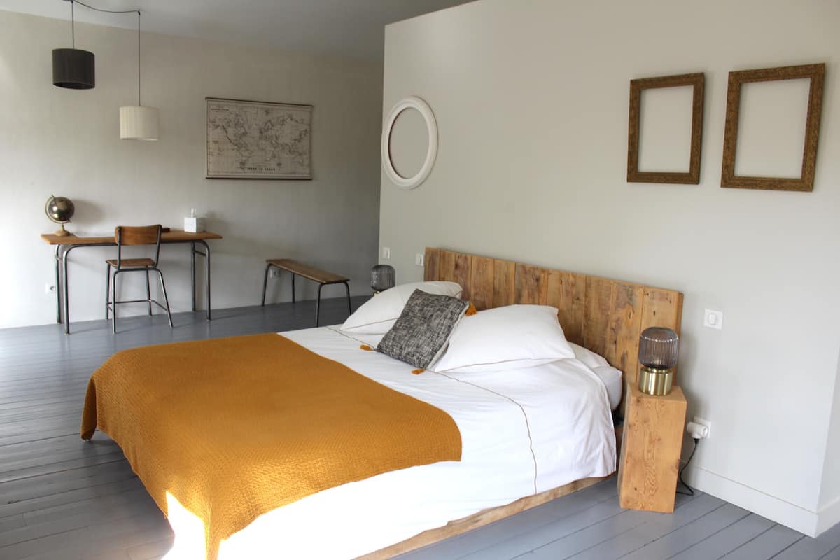 A bedroom with a wooden bed, a desk, and a chair.