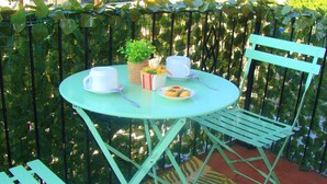 A round table with a white cup, a white saucer, a basket with a plant, and a plate with a pastry. - La Finestra sulla Fiera (Bologna)