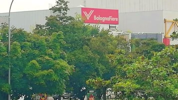 Un grande edificio industriale con un cartello rosso ben visibile con la scritta "BolognaFiere".